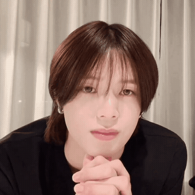 A Close Up Of A Person 'S Face With Their Hands Folded In Front Of Their Face GIF