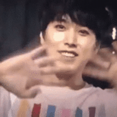 A Close Up Of A Person 'S Face With Their Hands In The Air . GIF