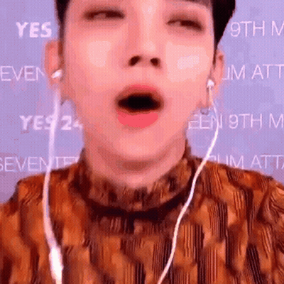 a close up of a person 's face with their mouth open and earphones .