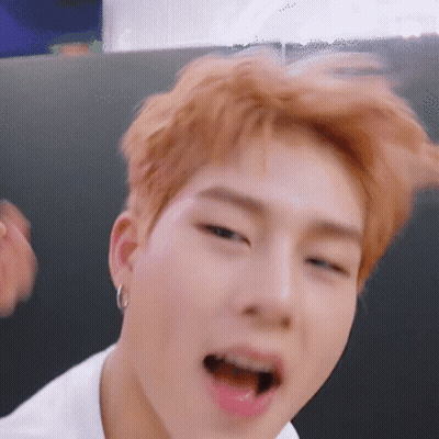 A Close Up Of A Person 'S Face With Their Mouth Open And Earrings . GIF