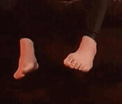 A Close Up Of A Person 'S Feet In A Dark Room With Red Lights . GIF
