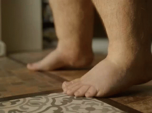 A Close Up Of A Person 'S Feet On A Tile Floor GIF