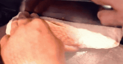 A Close Up Of A Person 'S Foot Being Wiped With A Napkin . GIF