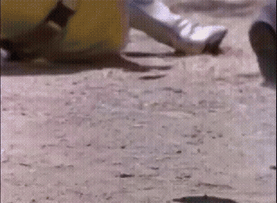A Close Up Of A Person 'S Foot On A Dirt Road . GIF