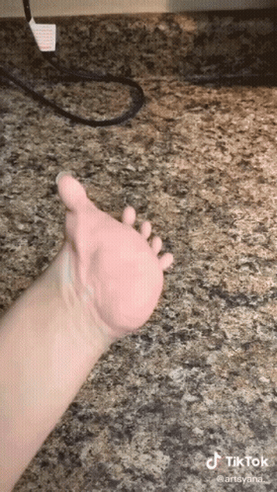 A Close Up Of A Person 'S Hand On A Granite Countertop . GIF