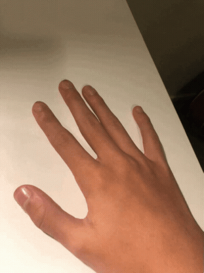 A Close Up Of A Person 'S Hand On A White Table GIF