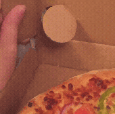 A Close Up Of A Person 'S Hand Reaching For A Pizza In A Box GIF