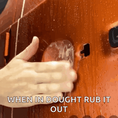 A Close Up Of A Person 'S Hand Rubbing A Glass With The Words When In Dough Rub It Out Below It GIF
