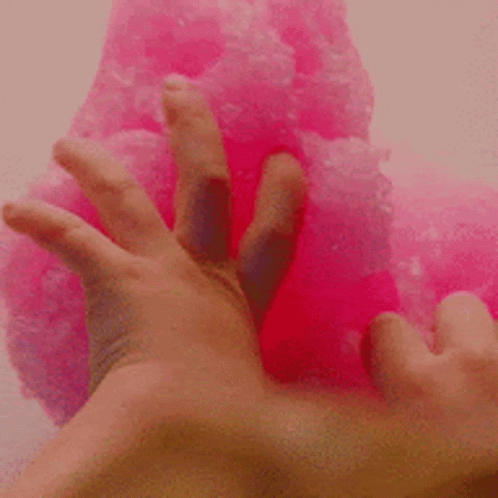 A Close Up Of A Person 'S Hand Touching A Pink Slime . GIF