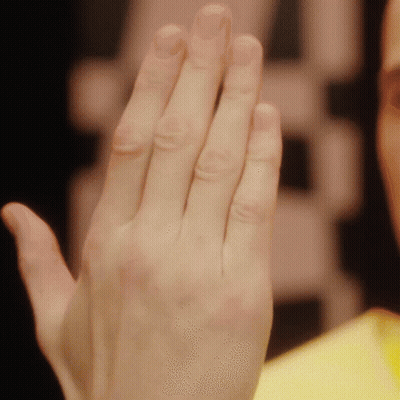 A Close Up Of A Person 'S Hand With A Yellow Shirt GIF