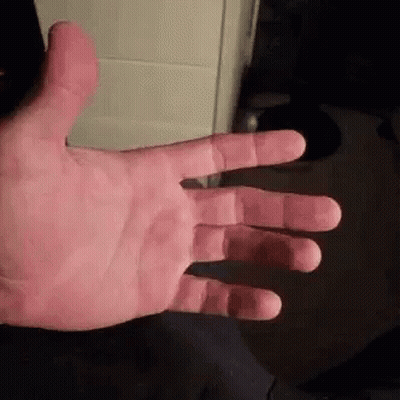 A Close Up Of A Person 'S Hand With Their Fingers Outstretched And A Black Background . GIF
