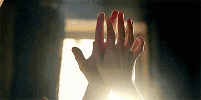 A Close Up Of A Person 'S Hands Giving Each Other A High Five In Front Of A Window . GIF