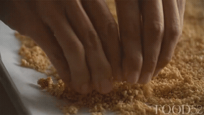 A Close Up Of A Person 'S Hands On A Pile Of Food52 GIF