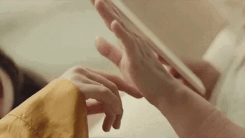 A Close Up Of A Person 'S Hands Playing With A Tablet . GIF