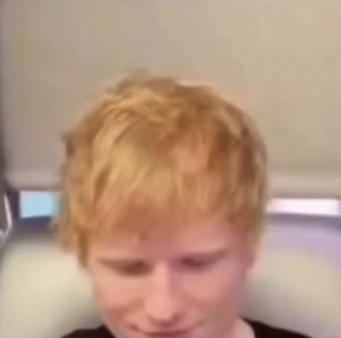 A Close Up Of A Person 'S Head With Red Hair And A Black Shirt . GIF