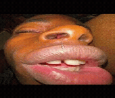 a close up of a person 's mouth with a piercing in it and their tongue sticking out .