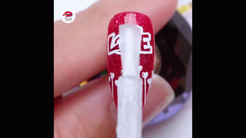 A Close Up Of A Person 'S Nails Being Painted With Red And White Polish . GIF