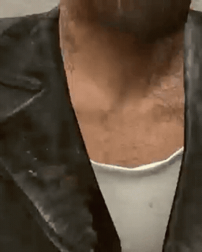 A Close Up Of A Person 'S Neck With A Leather Jacket On . GIF