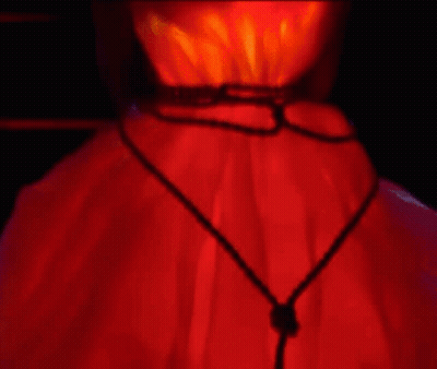 A Close Up Of A Person 'S Neck With A Red Light Behind It . GIF
