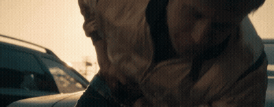 A Close Up Of A Person 'S Torso While Standing Next To A Car GIF
