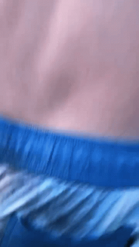 A Close Up Of A Person 'S Torso With Blue Shorts On GIF