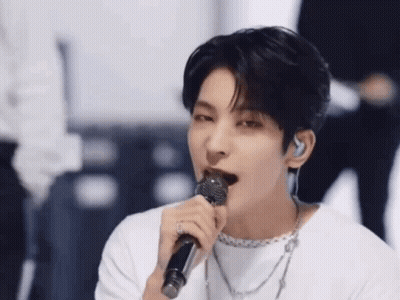 A Close Up Of A Person Singing Into A Microphone . GIF