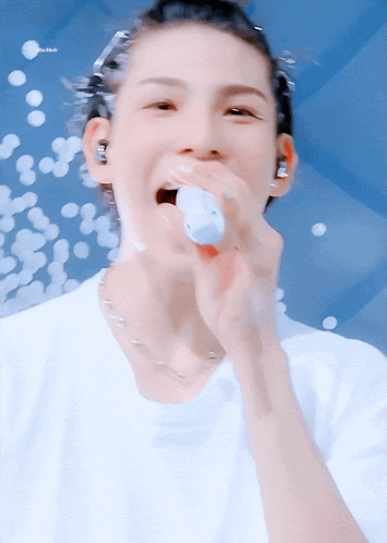 A Close Up Of A Person Singing Into A Microphone With The Word Bubbles In The Background GIF