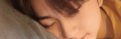 A Close Up Of A Person Sleeping On A Bed With Their Eyes Closed . GIF