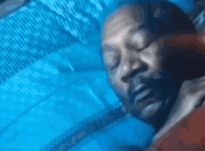 A Close Up Of A Person Sleeping On A Blue Blanket GIF