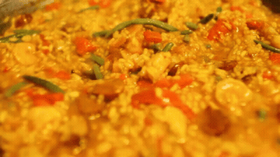 A Close Up Of A Person Stirring A Pot Of Food With A Fork . GIF