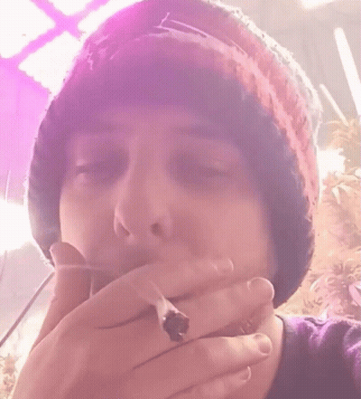 A Close Up Of A Person Wearing A Beanie And A Purple Shirt GIF