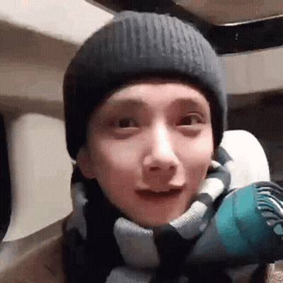 A Close Up Of A Person Wearing A Beanie And A Scarf . GIF
