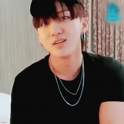 A Close Up Of A Person Wearing A Black Hat And A Necklace GIF