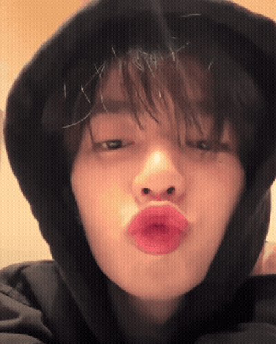 A Close Up Of A Person Wearing A Black Hoodie Making A Kissing Face GIF