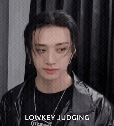 A Close Up Of A Person Wearing A Black Jacket And A Black Necklace . GIF