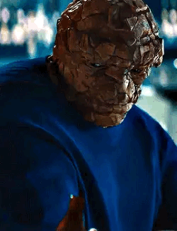 A Close Up Of A Person Wearing A Blue Shirt With A Mask On Their Face . GIF