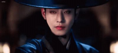 A Close Up Of A Person Wearing A Hat And A Blue Costume . GIF