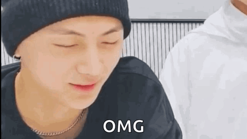 A Close Up Of A Person Wearing A Hat And A Necklace With The Word Omg Written On It . GIF