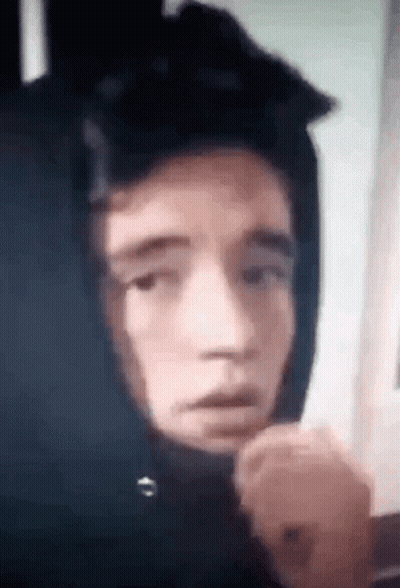 A Close Up Of A Person Wearing A Hoodie With A Hood On Their Head . GIF