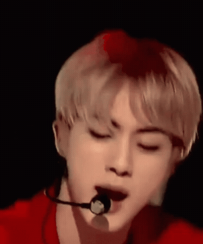A Close Up Of A Person Wearing A Microphone With Their Eyes Closed . GIF