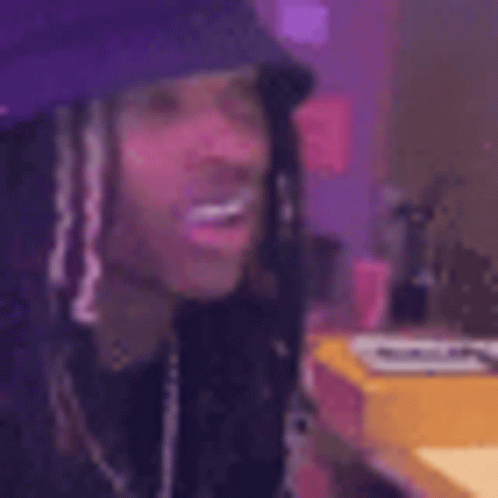 A Close Up Of A Person Wearing A Purple Hat And Dreadlocks . GIF