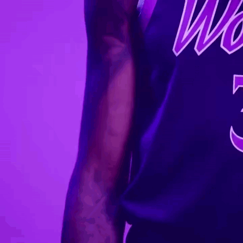 A Close Up Of A Person Wearing A Purple Jersey With The Word Wolves On It GIF