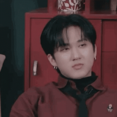A Close Up Of A Person Wearing A Red Shirt And Tie Making A Funny Face . GIF
