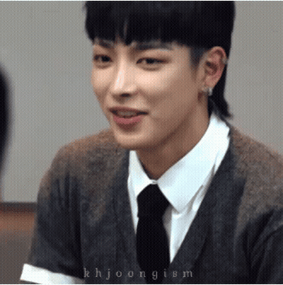 A Close Up Of A Person Wearing A Sweater And Tie GIF
