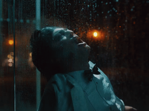 A Close Up Of A Person Wearing A White Coat With A Black Background GIF