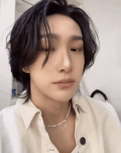 A Close Up Of A Person Wearing A White Shirt And A Pearl Necklace . GIF