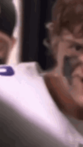 A Close Up Of A Person Wearing A White Shirt With A Purple Number On The Back . GIF