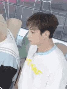 A Close Up Of A Person Wearing A White T-Shirt And A Blue Collar . GIF