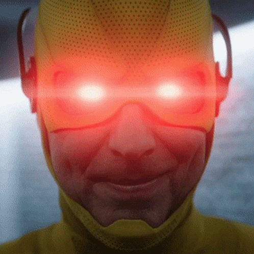 A Close Up Of A Person Wearing A Yellow Superhero Costume With Red Eyes GIF