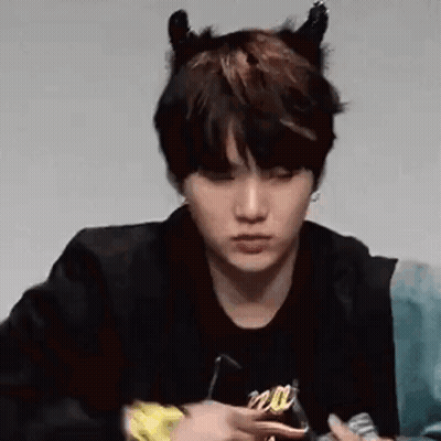 A Close Up Of A Person Wearing Devil Horns And A Black Jacket . GIF
